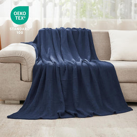 Navy EMME blanket draped over bed showing generous 90x90 size.