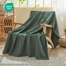 EMME cotton muslin blanket on sofa demonstrates breathable comfort.