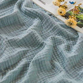 EMME cotton muslin large throw blanket on couch, breathable comfort for evenings.