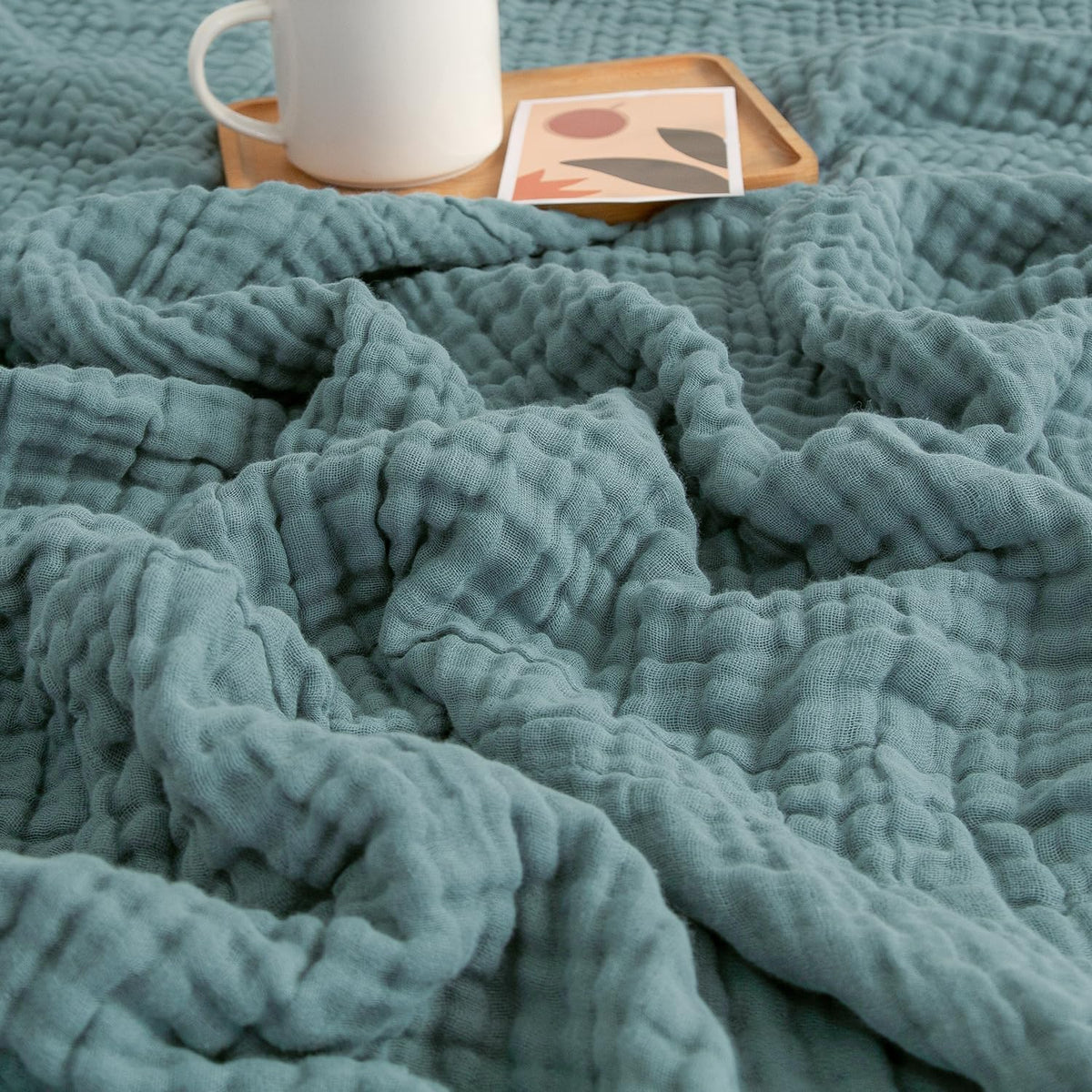 EMME Muslin Blanket teal 60x80 on a comfy couch showing all-season coverage