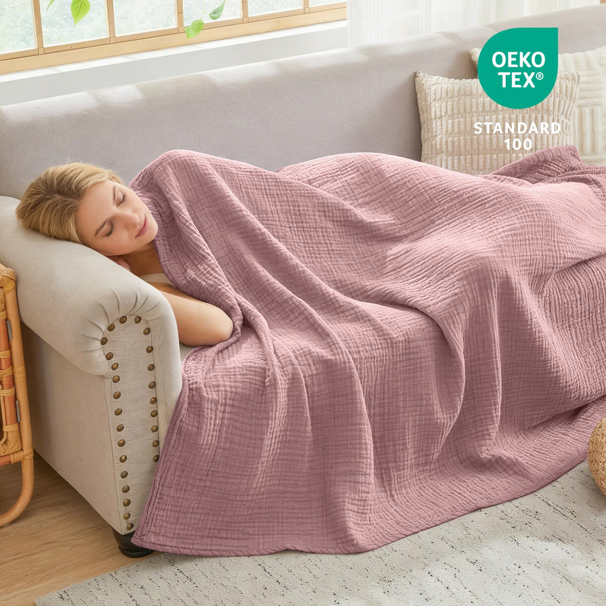 EMME muslin throw blanket draped over a sofa for comfort.