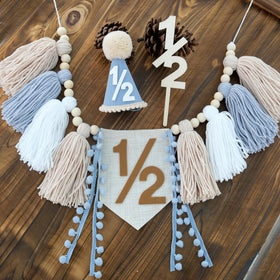 Ereniko half birthday banner for baby boy with blue and khaki tassels.