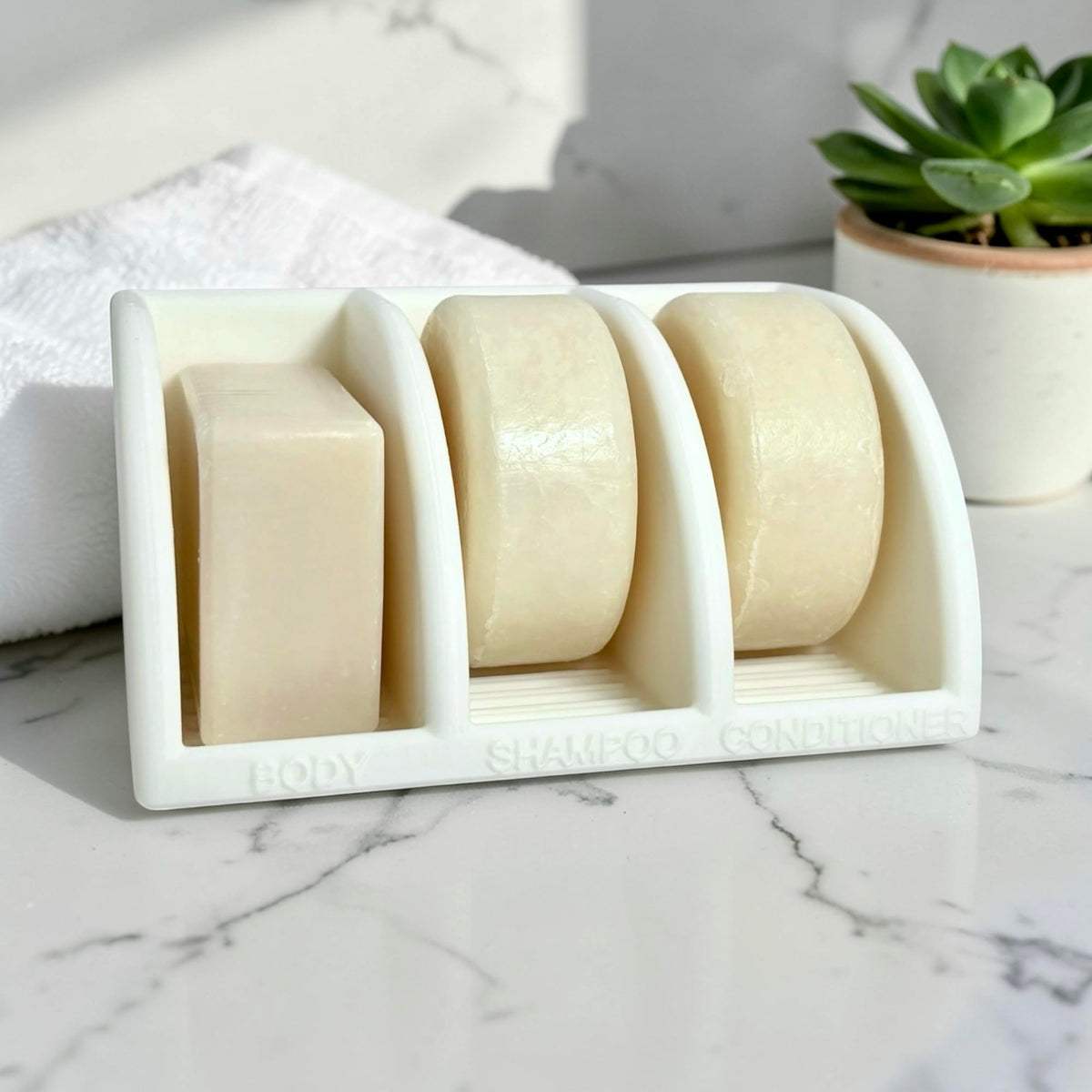 Essence & Abode Jade White shampoo bar holder keeps bars dry after use.
