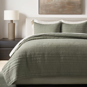 Evergracehome modern lines quilt king olive green folded to showcase texture and lightweight warmth.