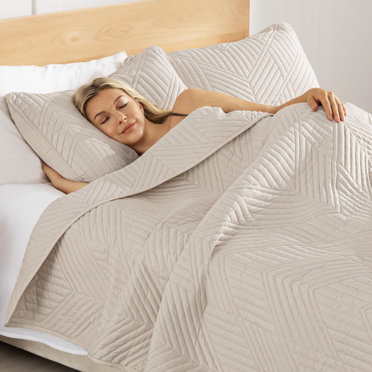Exclusivo Mezcla all-season quilt in a cozy bedroom ambience suggests year-round comfort.
