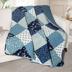 Exclusivo Mezcla quilted throw with blue boho patchwork draped over a sofa for cozy styling