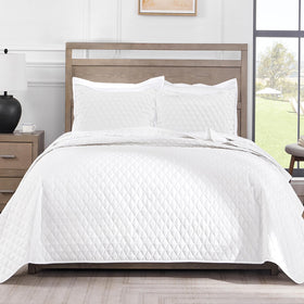 Exclusivo Mezcla reversible king quilt set on bed, soft all-season comfort.