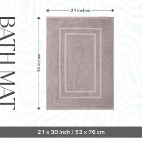 Taupe Feather and Stitch New York bath mat highlights soft cotton terry under feet.