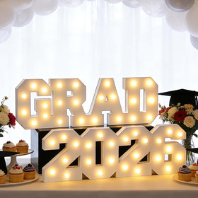 FestalMart GRAD 2026 letters lit on a table create a bright graduation centerpiece.