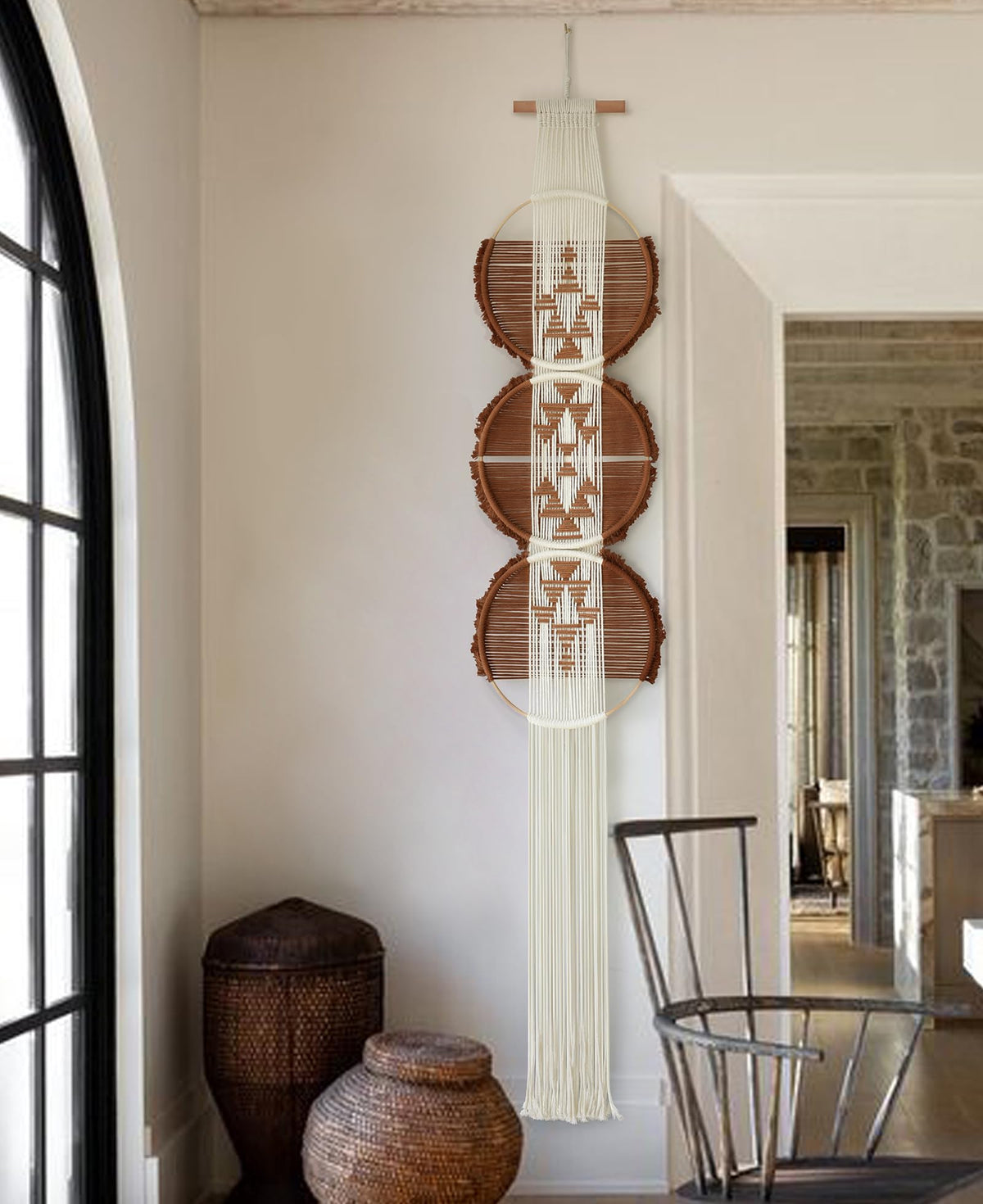 Flber macrame wall hanging with three circles adds subtle texture to modern living rooms.