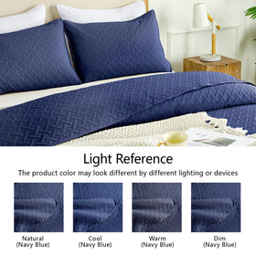 Navy quilt styled on a bed with coordinating sheets for a serene bedroom scene