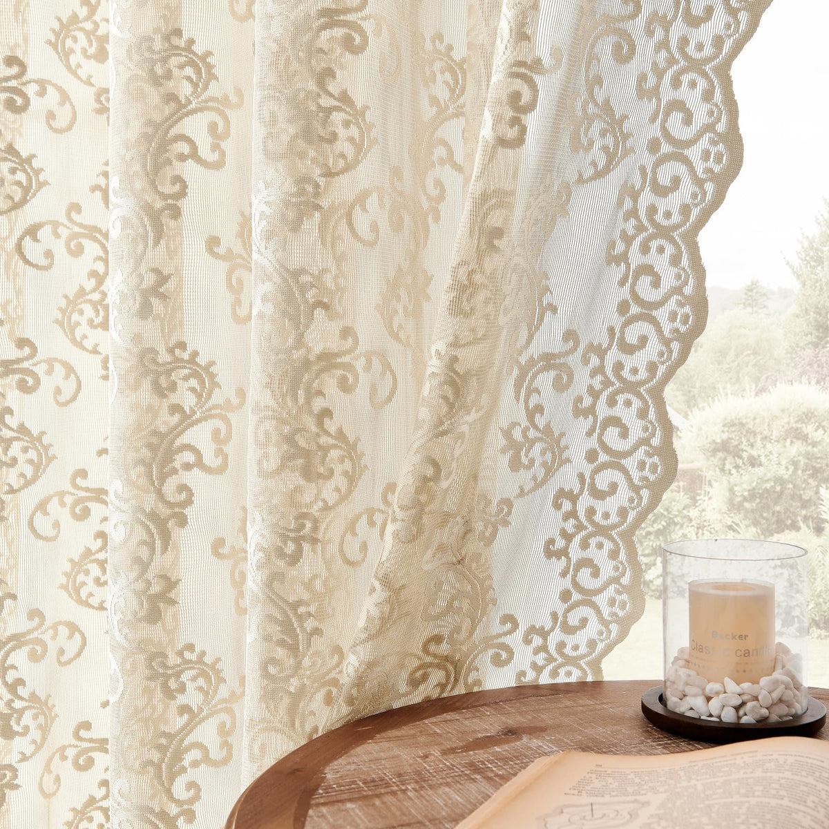 Folkside beige lace curtains frame a living room, softly filtering daylight.