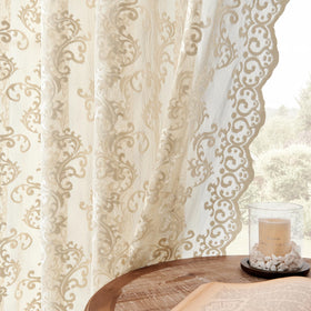 Folkside beige lace curtains frame a living room, softly filtering daylight.