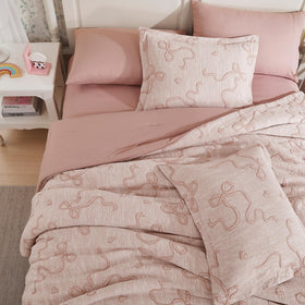 Geniospin pink twin bedding in a dorm room setup for easy styling