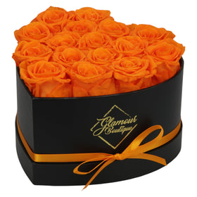 GLAMOUR BOUTIQUE 16-rose Forever Heart Box close-up; vibrant orange preserved roses centerpiece.