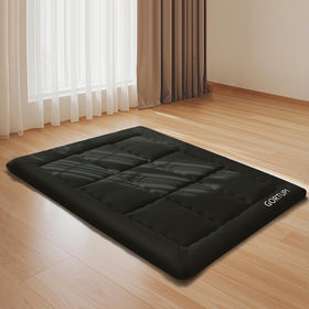GORTUPI foldable futon mattress with elastic strap for easy transport.