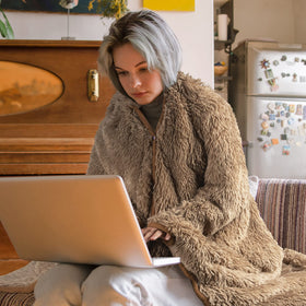 Happy Fuel wearable blanket draped over shoulders during outdoor coffee breaks.
