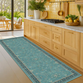 Hazo Haus teal rug with navy border adds depth to decor.