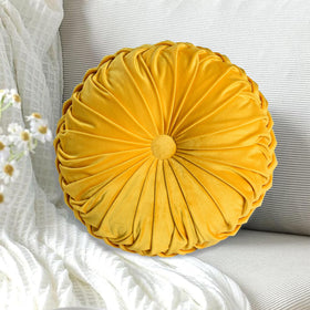 HIG yellow ruched velvet round pillow on sofa adds cozy decor.