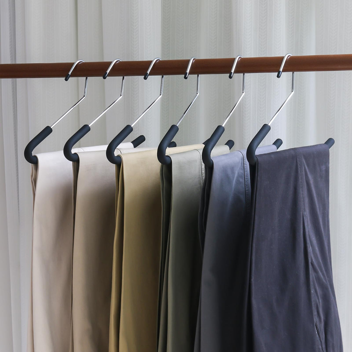 Homa Jia jeans neatly hanging on foam-padded hangers.