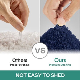 HOMEIDEAS U-shaped mat in navy complements other mats for a cohesive bath.