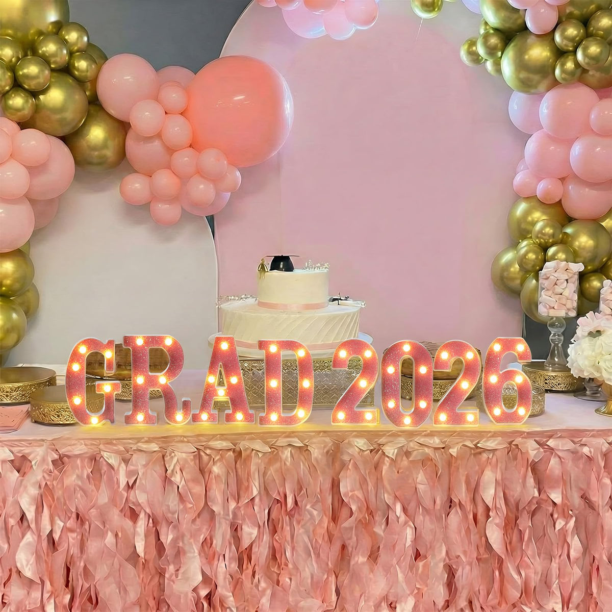 Honoson Grad 2026 pink LED sign used as a table centerpiece.