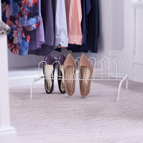 Household Essentials white metal rack stays low to the ground, avoiding garment interference.