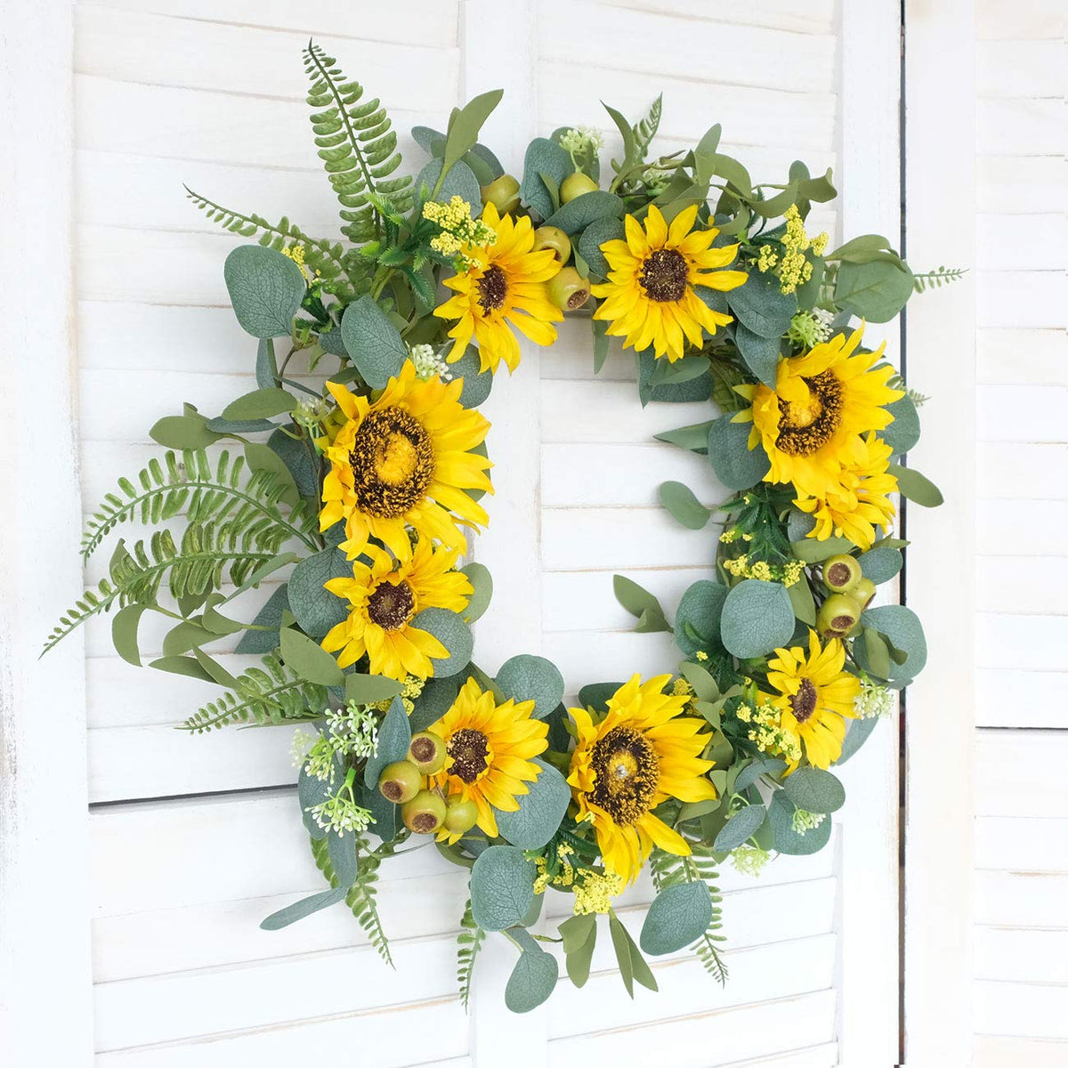 Rustic farmhouse style Idyllic wreath enhances porch with warm yellow blooms.