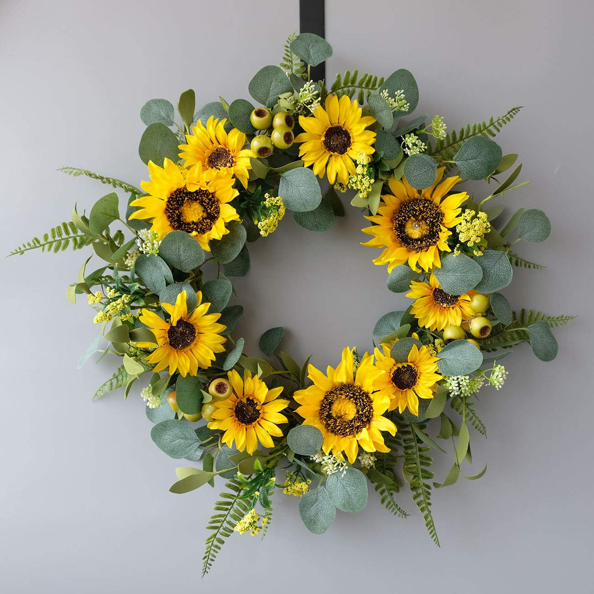 Idyllic wreath used as window decor with bright yellow sunflowers.