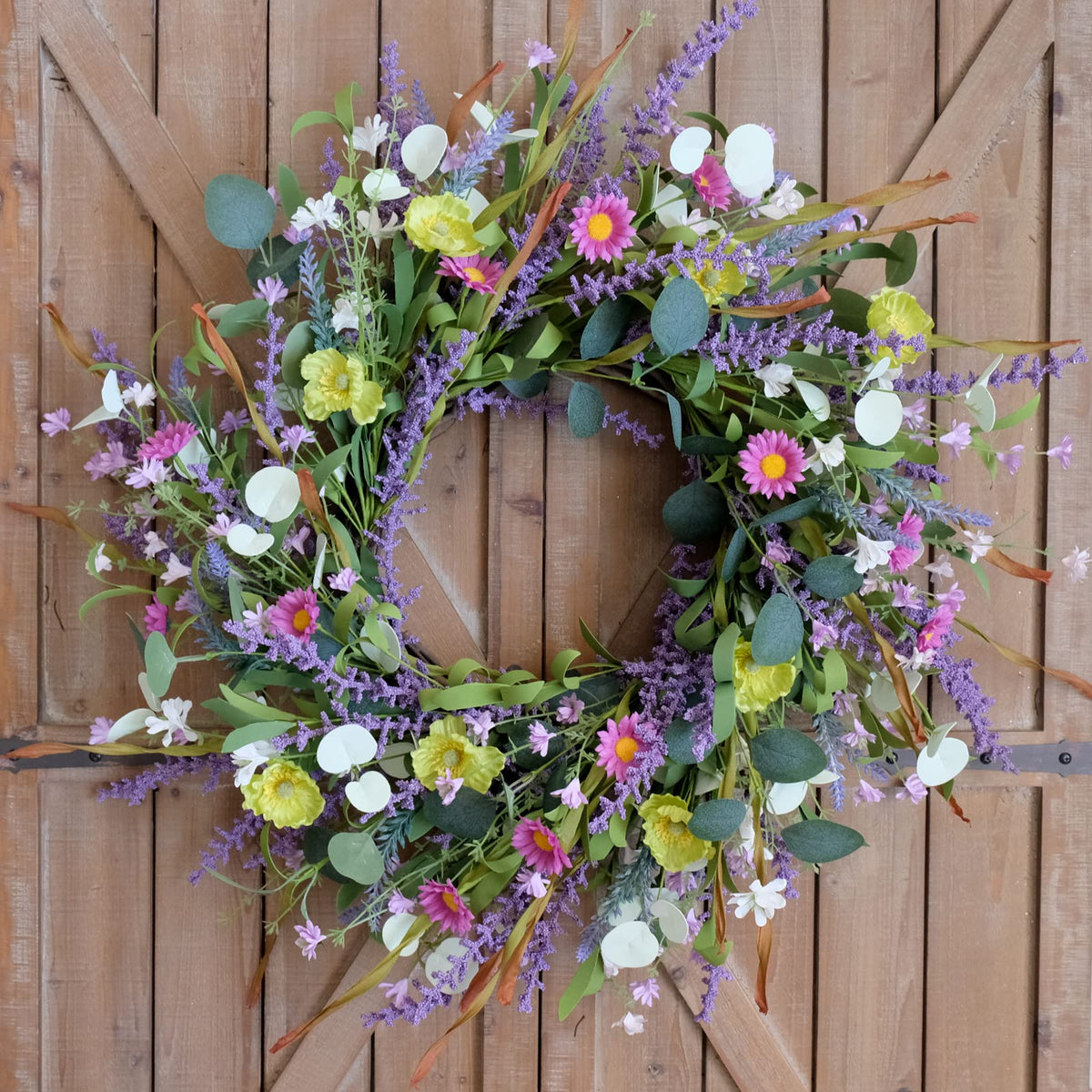 Idyllic wildflowers and greenery adorn doors for seasonal charm.