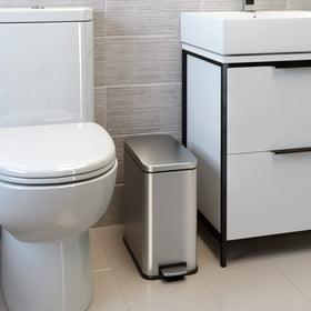 iTouchless slim-profile trash bin fits narrow gap between toilet and vanity.