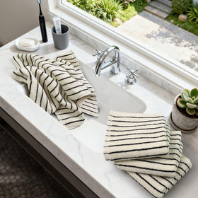 Jacquotha hand towels shown on a bathroom bar, highlighting classic stripe design.