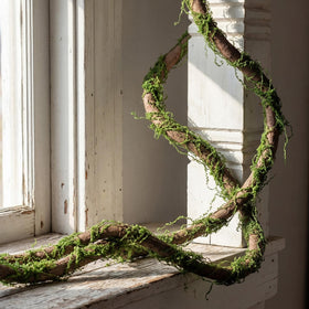 Janinka 118in bendable branches with moss create a flexible, natural backdrop for events.