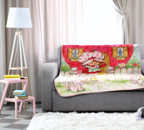 Jay Franco Strawberry Shortcake plush throw in dorm setting, compact warmth for studying.