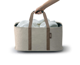 Joseph Joseph Hold-All full-load laundry scene highlights easy one-handed carrying.