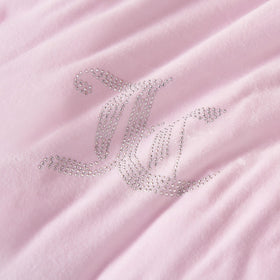 Juicy Couture soft velour fabric on a styled bed conveys warmth and inviting lounging evenings