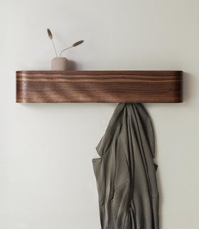 Kazai Toke wall mounted coat rack with hidden hooks for clutter-free entryways.