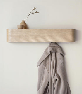 Kazai Toke wall-mounted coat rack in entryway with visible dark wood veneer and hidden hooks