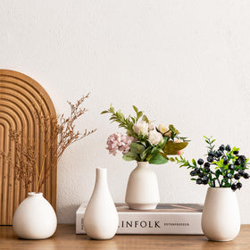 Kendiis wedding table centerpieces using small ceramic bud vases.