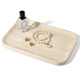 Koville Romano Travertine Tray on a beige vanity with jewelry and cosmetics neatly arranged