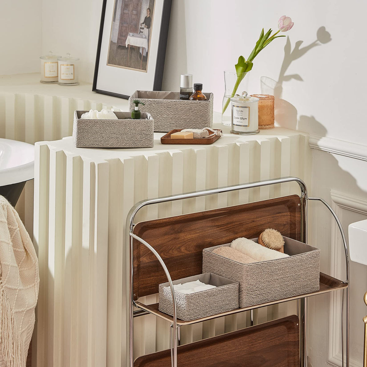 La Jolie Muse baskets stacked on bathroom shelves for towels and toiletries.
