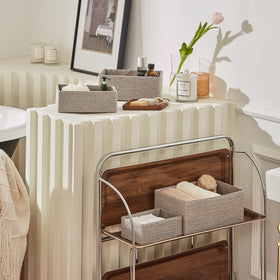 La Jolie Muse baskets stacked on bathroom shelves for towels and toiletries.