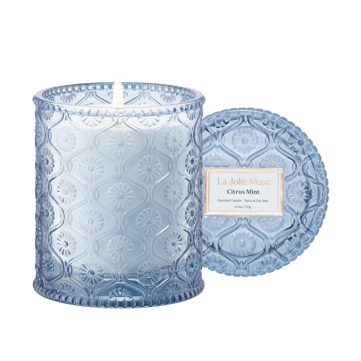 La Jolie Muse Citrus Mint Candle in embossed daisy jar enhances décor and scent.