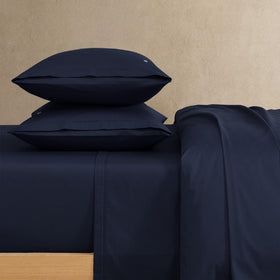 Lacoste percale fitted sheet close-up showing secure fit and smooth finish.