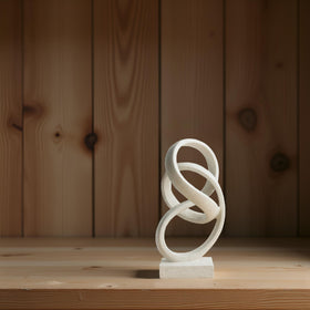 Laikearts white ribbon sculpture on a shelf adds refined visual harmony
