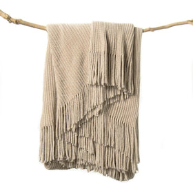 Lifein beige throw blanket on a couch adds cozy boho charm
