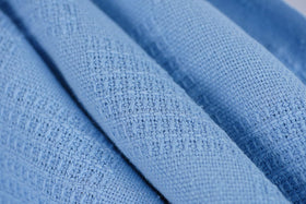 Unfolded blue Linteum Textile blanket showing large, breathable warmth.
