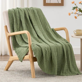 Love's cabin sage-green muslin blanket spread on a bed, breathable and soft