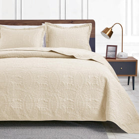Love's cabin coin-pattern quilt on beige queen bed for year-round comfort