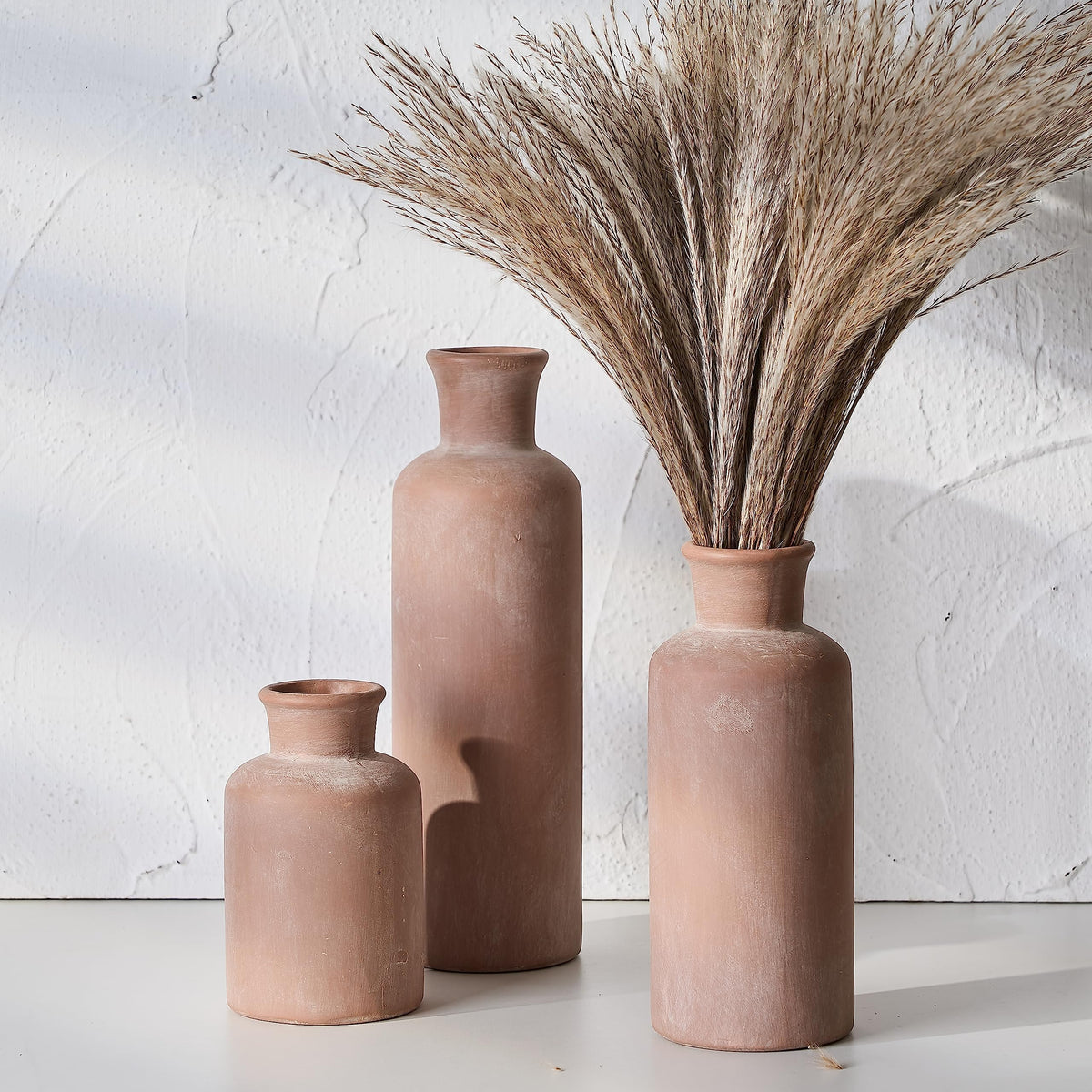LUKA ceramic rustic vase set of 3 on a living room display in warm terracotta tones.